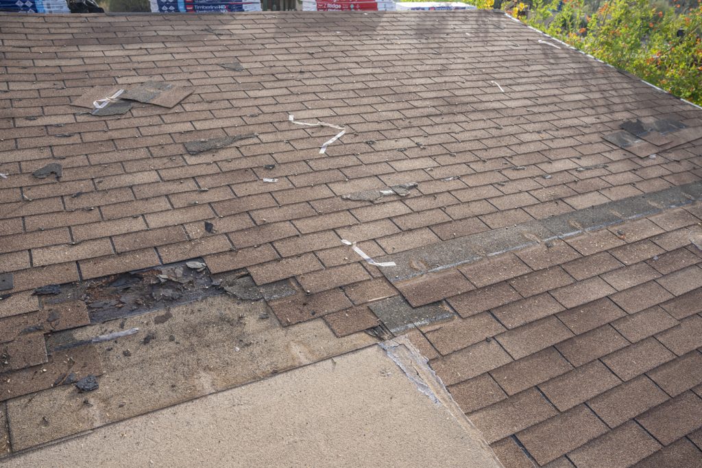 A residential roof with missing shingles in reference to the question "How to know if you need a roof repair"